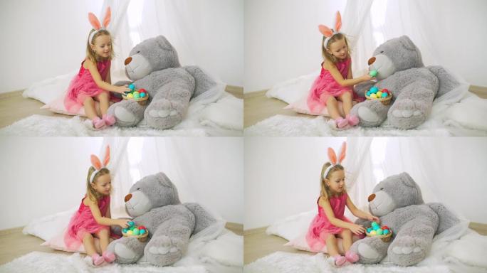 小女孩喂大玩具熊复活节彩蛋