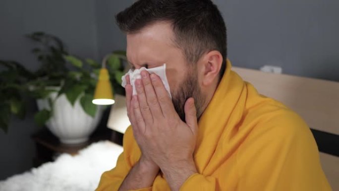 盖伊咳嗽。迷人的白人年轻男子剧烈咳嗽，并用餐巾纸捂住嘴。感冒、流感、喉咙痛、急性呼吸道疾病的概念。慢