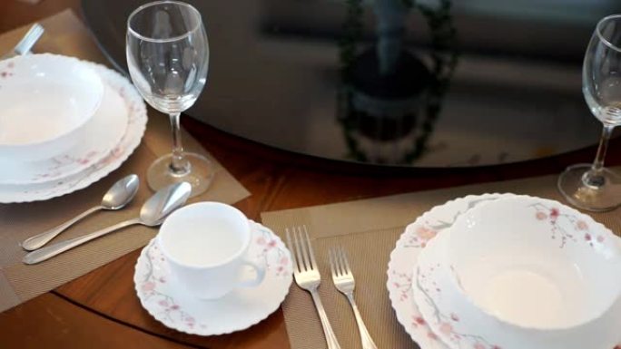 在室内举行婚礼或活动派对时，配有陶器和眼镜的圆桌设置。
