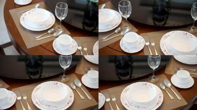 在室内举行婚礼或活动派对时，配有陶器和眼镜的圆桌设置。