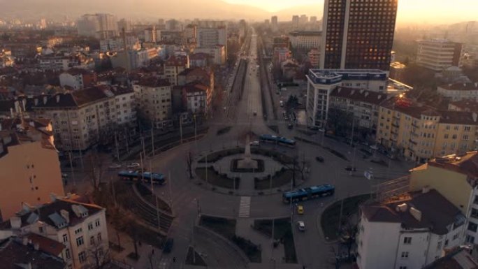 日落时分，保加利亚首都索非亚，公共汽车和公共交通工具在环岛上穿梭