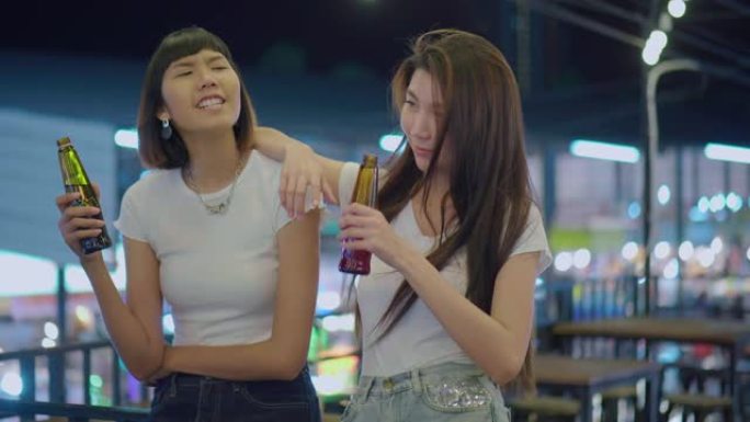 年轻的亚洲妇女与朋友在晚上庆祝