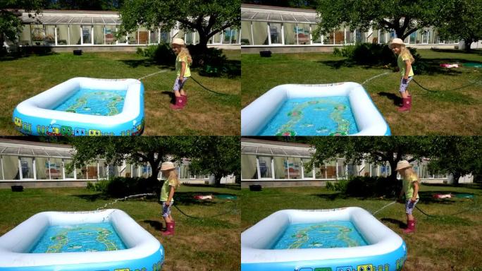 金发女孩在乡村别墅用水管填充充气游泳池。万向节运动