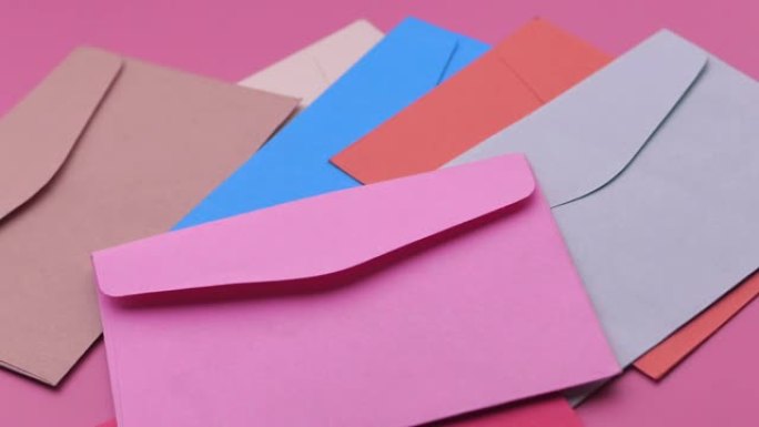 粉红色背景上彩色信封的特写