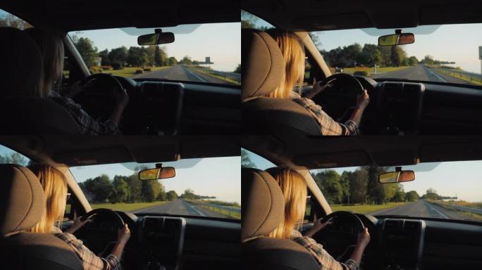 在美国郊区驾驶汽车的迷人中年妇女的后视图