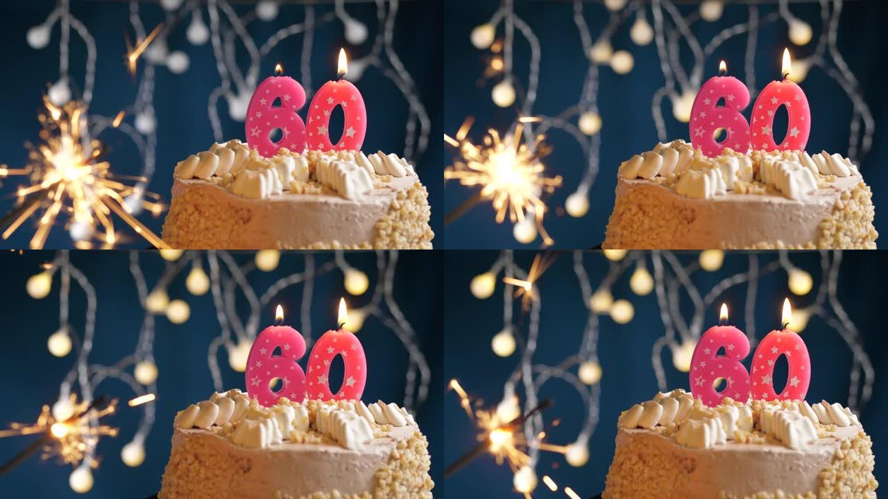 生日蛋糕，蓝色背景上有60个粉色蜡烛和烟火。慢动作和特写视图