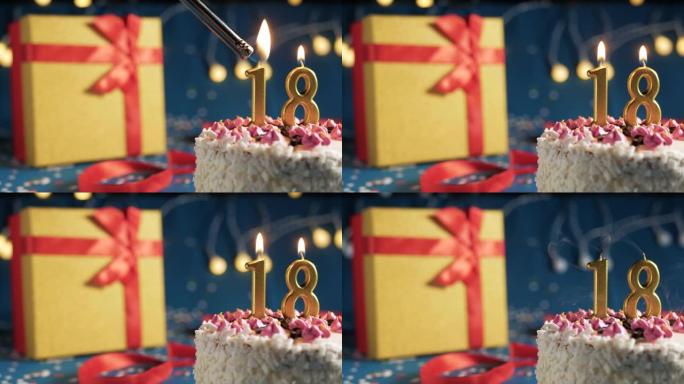白色生日蛋糕编号18点灯燃烧的金色蜡烛，蓝色背景带灯和用红丝带绑起来的礼物黄色盒子。特写