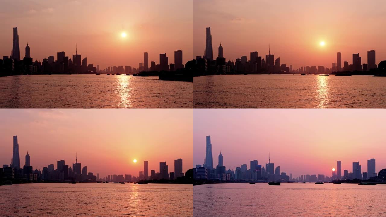 上海日落的延时镜头，外滩天际线和黄浦江背景，货船在河上航行，太阳向下移动到地平线，4k视频。