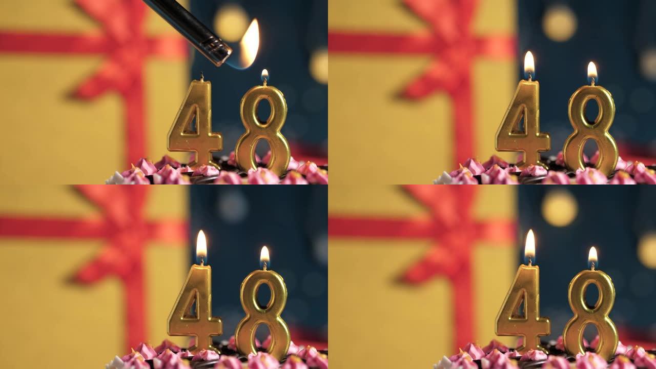 生日蛋糕编号48点灯燃烧的金色蜡烛，蓝色背景礼物黄色盒子用红丝带绑起来。特写和慢动作