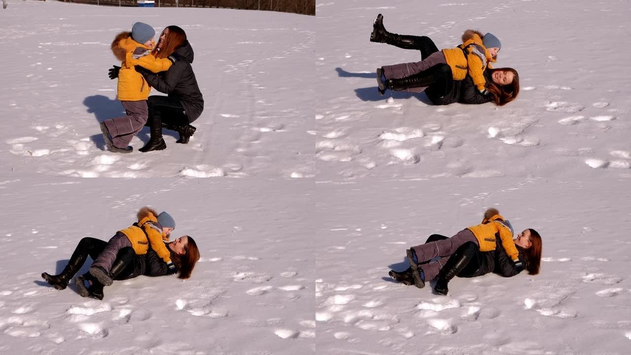 小男孩穿过雪地跑到他母亲的怀里，他们落在雪地上。