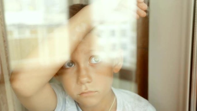 窗户附近一个悲伤男孩的肖像
