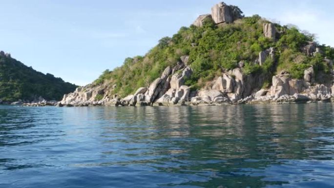 绿色热带异国天堂岛附近平静的水。泰国阴天，绿陶岛丘陵潜水胜地附近的宁静海水。从船上看。
