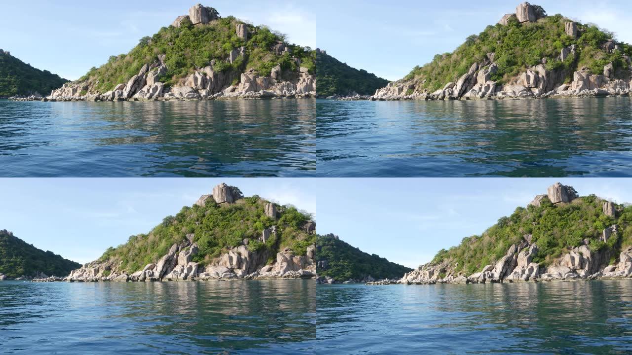 绿色热带异国天堂岛附近平静的水。泰国阴天，绿陶岛丘陵潜水胜地附近的宁静海水。从船上看。
