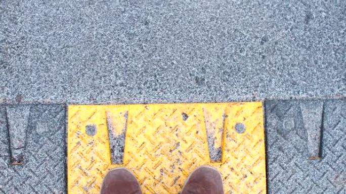 一个穿着冬靴的男人在路上行走的腿的特写镜头。