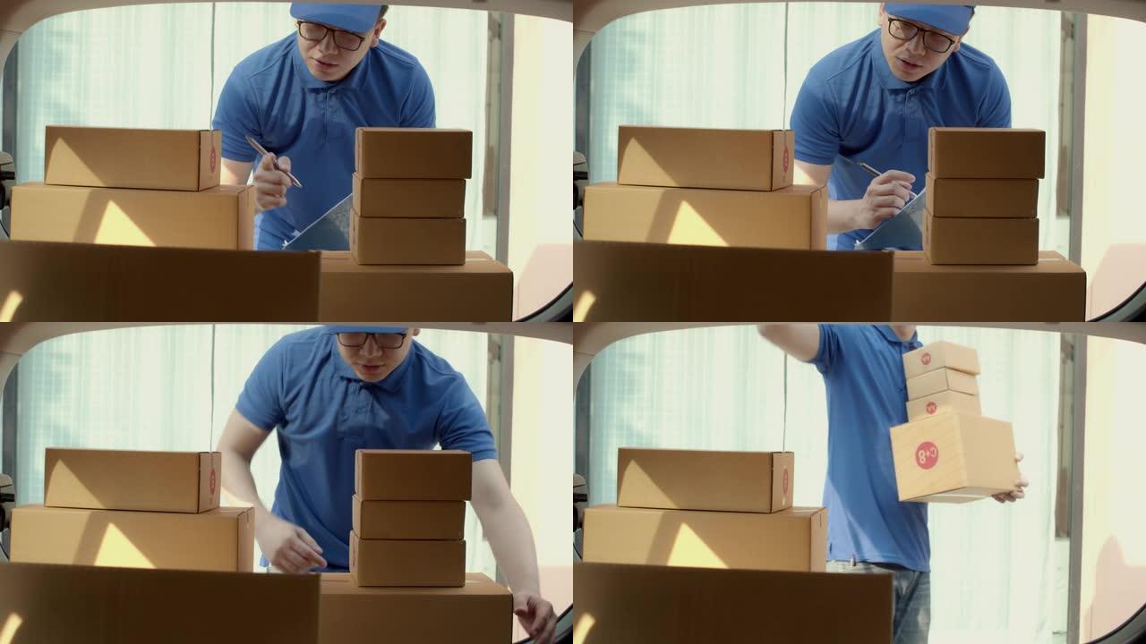 亚洲送货员在送货车后部检查和携带纸质包裹箱。邮政递送服务的概念。4k UHD中的慢动作。