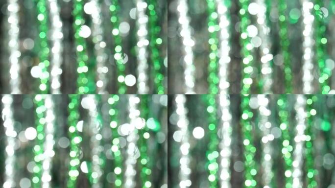 神奇的抽象闪亮背景，银色和绿色散焦的波克。美丽的动态背景在闪亮的灯光和闪闪发光的颗粒。节日气氛。圣诞
