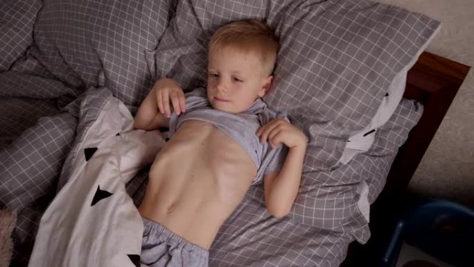 一个患有水痘和红疹的小男孩躺在床上。