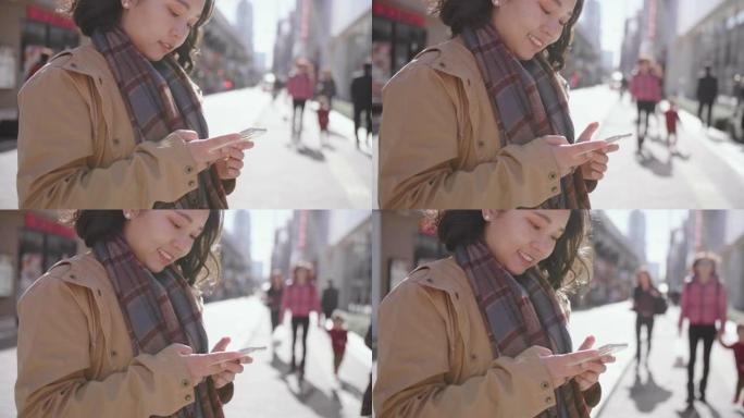 年轻女子在城市外面发短信智能手机。
