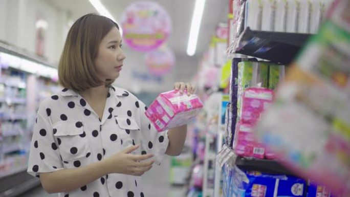 年轻的亚洲女性在超级市场购物