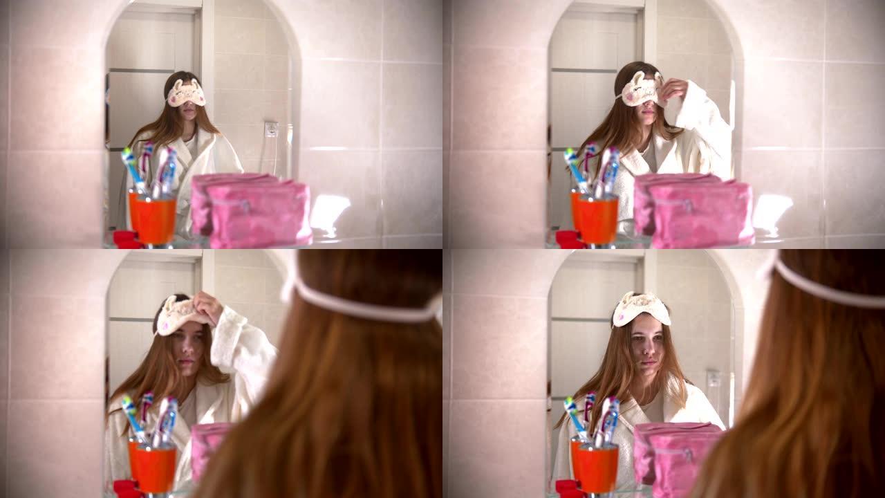 一名年轻女子脱下睡觉的面具，看着镜子里的自己