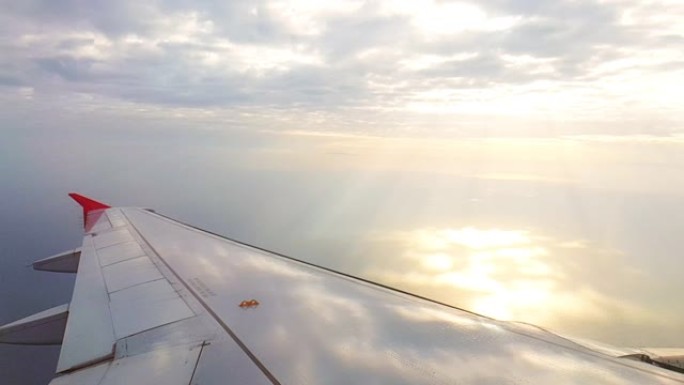 从飞机窗口可以看到海中日出的美丽景色