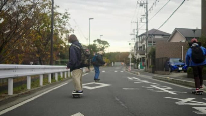 日本年轻女滑板运动员骑在住宅区的道路上