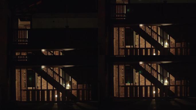 昏暗的废弃建筑中的旧木制楼梯，带有红色砖墙