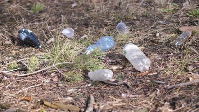 环境的塑料污染。草中的塑料瓶和其他不可降解废物。运动4k视频，4096x2160镜头