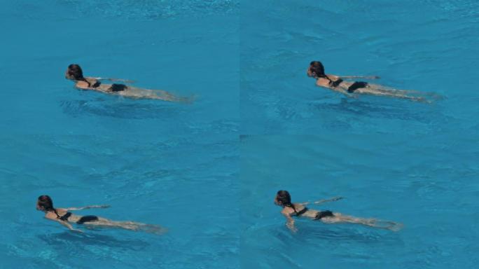 女人在蓝色的水池上游泳