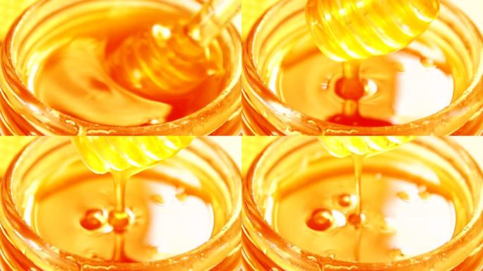 蜂蜜从玻璃碗中的蜂蜜北斗七星滴落。特写。健康有机浓蜂蜜从玻璃蜜勺蘸，特写。