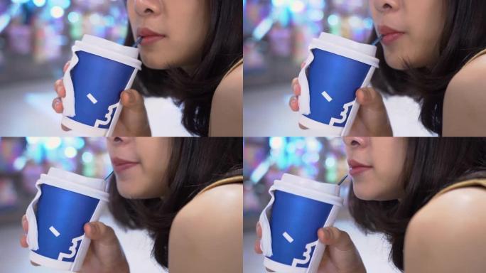 4k年轻的亚洲女士，一杯热拿铁咖啡，坐下来放松，喝咖啡休息，少糖咖啡，咖啡因成瘾，昏昏欲睡的症状，整