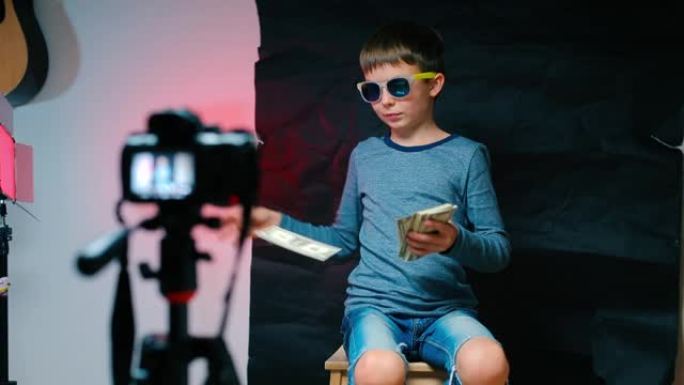 一个百万富翁男孩将钱投入摄像机，录制视频。