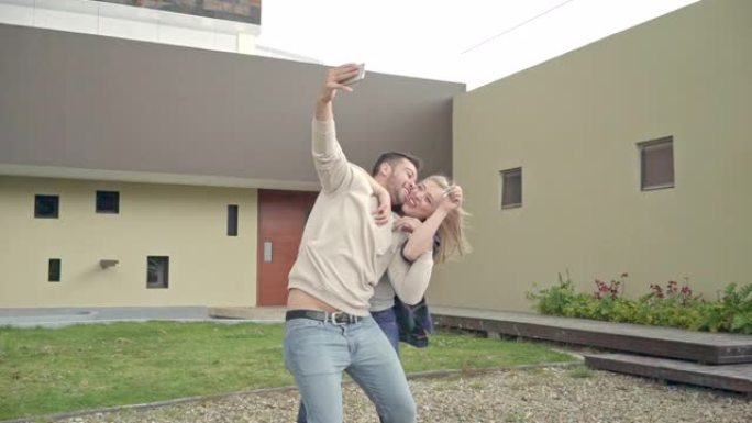 拉丁夫妇在他们的新房子外面自拍，展示他们的房子钥匙