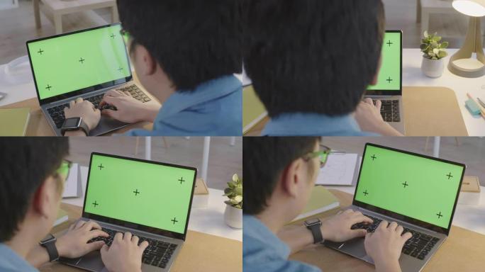 办公室工作人员在带有绿色屏幕的笔记本电脑上打字