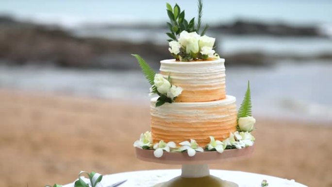 美丽的婚礼蛋糕装饰着鲜花和橙色。