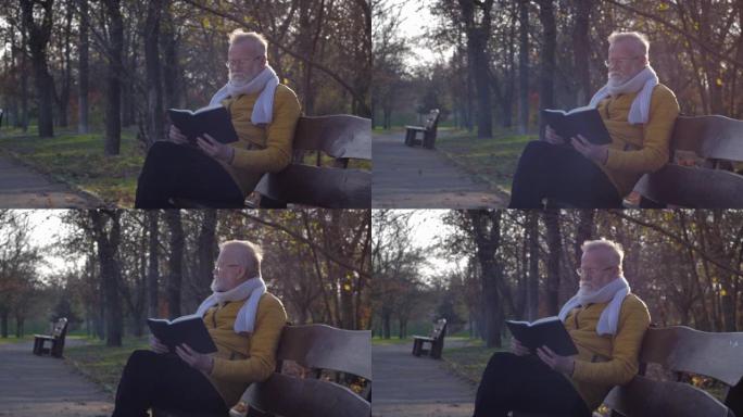 退休休闲，中年老人坐在秋天公园的长凳上看书