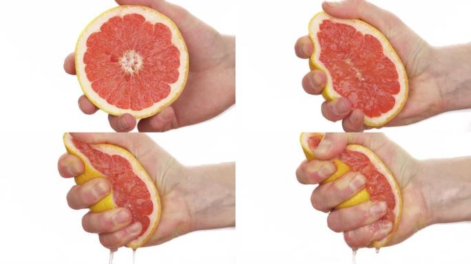 无法辨认的人挤压一半成熟多汁的葡萄柚的特写镜头。新鲜柑橘汁下降。孤立，在白色背景上