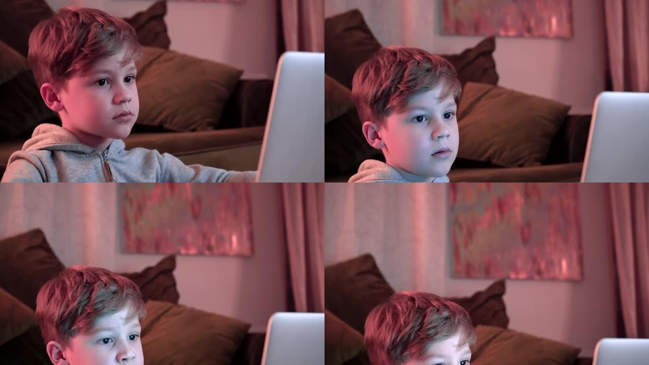 玩电子游戏和使用电脑的孩子。男孩专注于看着电脑屏幕。未来的rgb背光