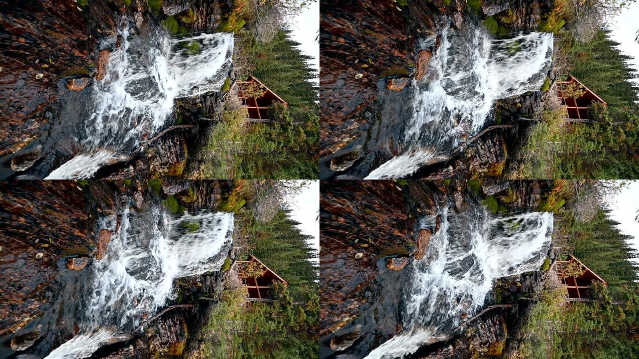 瀑布在班夫国家公园艾格尼丝湖的秋季森林中流动着木制茶馆