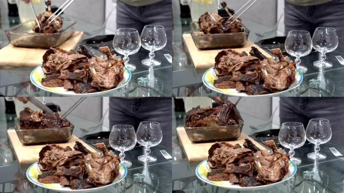 一个盘子的特写镜头，前景是油炸家禽的碎片。在模糊的背景中，一名男子用菜刀在木砧板上切割烤鸭。不露面。