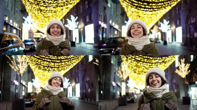 快乐大笑的年轻女子穿着保暖的冬装快速嬉戏地走在夜晚的城市街道