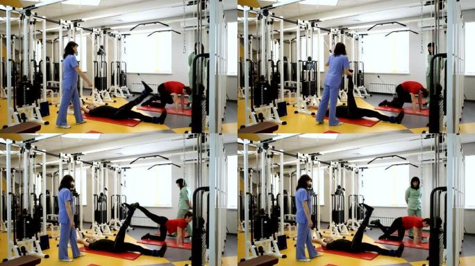 男女在健身房的健身器材上用腿举重。高清