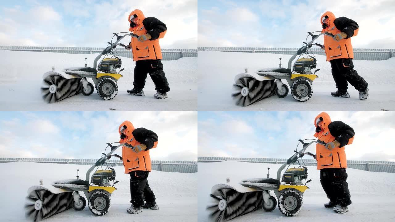 男子在冬天用扫地机清理院子里的雪