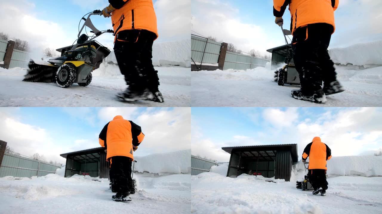 男子在冬天用扫地机清理院子里的雪