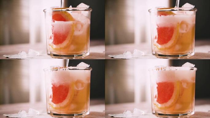 酒保正在准备一杯含有葡萄柚和冰的鸡尾酒，慢动作。葡萄柚鸡尾酒，特写。