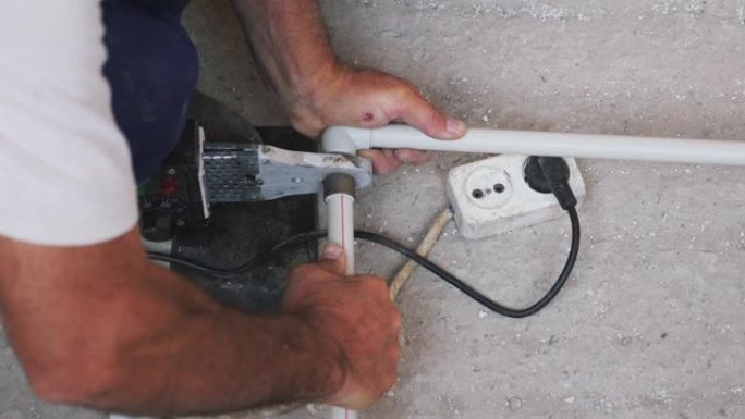 水管工用手焊接金属塑料管。烙铁和管子。施工概念