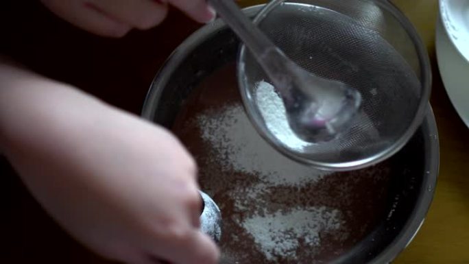 用筛子过滤玉米淀粉。用勺子搅拌。制作手工蛋糕的准备工作。看过去。