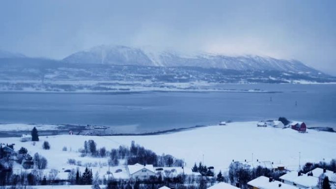 挪威北极降雪期间的特罗姆瑟冬季天际线