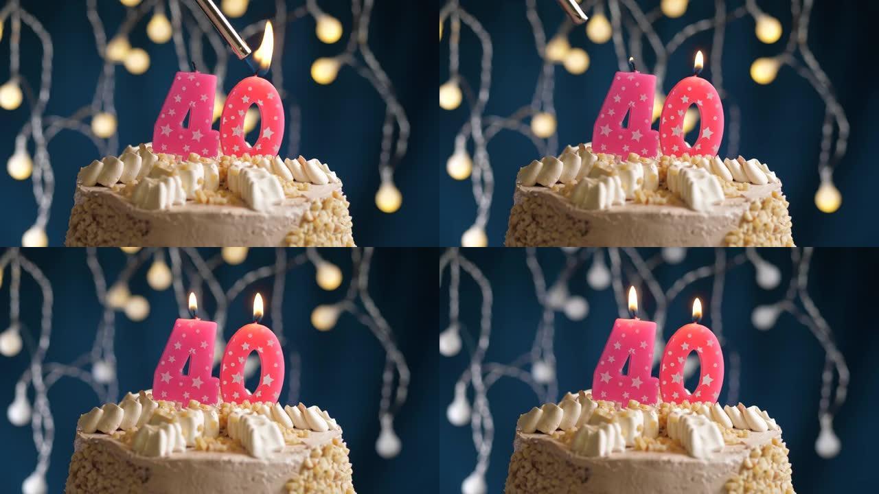 蓝色背景上有40号粉色蜡烛的生日蛋糕。蜡烛着火了。慢动作和特写视图