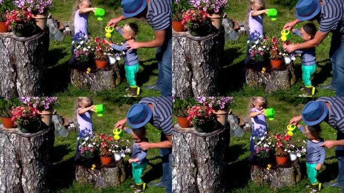 父亲教孩子如何在花园里浇花。女儿和儿子